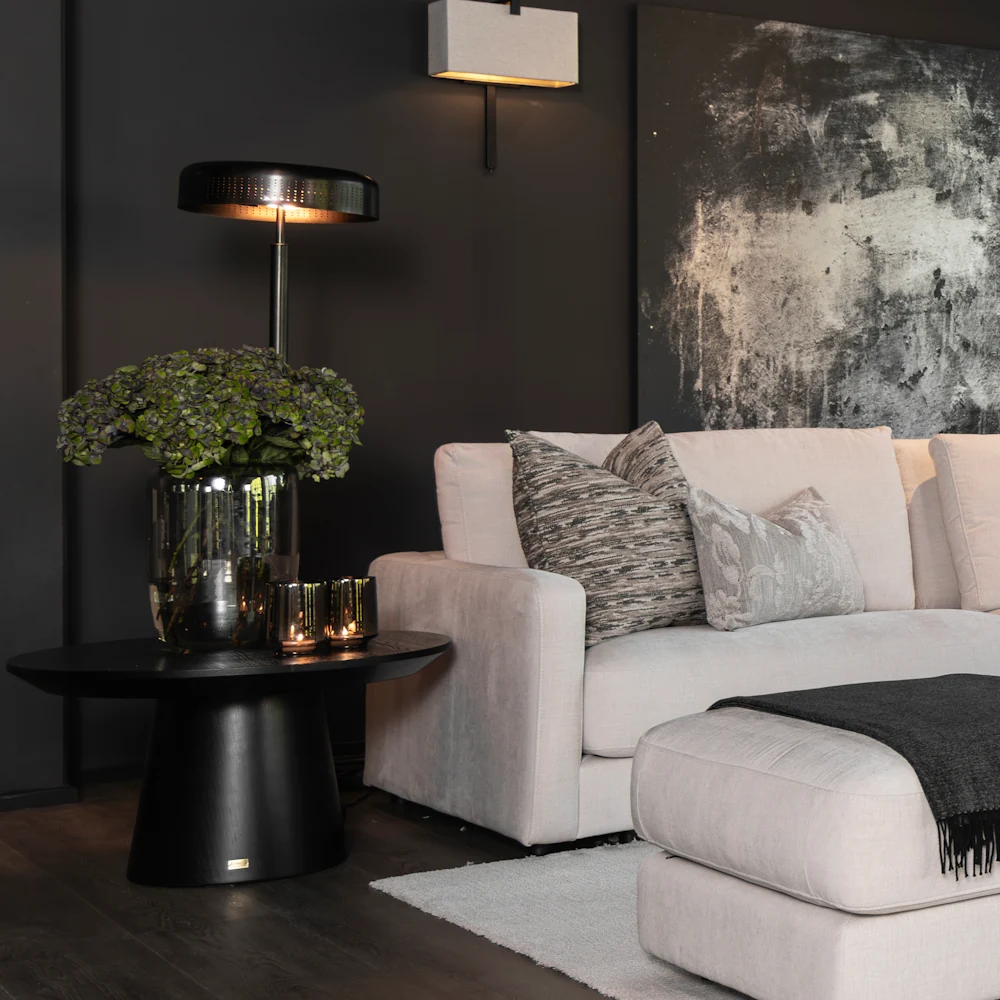 Artwood black Cloud 80cm coffee table with a vase of flowers sitting on top.