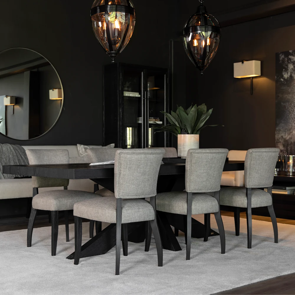 Lifestyle image of six Mandy Dining Chair in Sway Liver fabric around a black dining table.